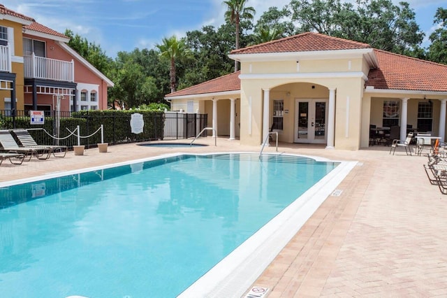 view of swimming pool featuring a patio area and french doors