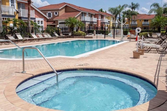 view of pool with a community hot tub and a patio