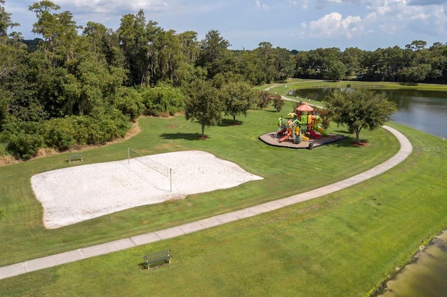 view of home's community featuring a lawn, volleyball court, a playground, and a water view