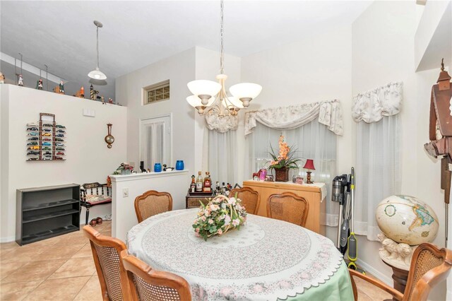 dining area featuring an inviting chandelier, baseboards, and light tile patterned flooring