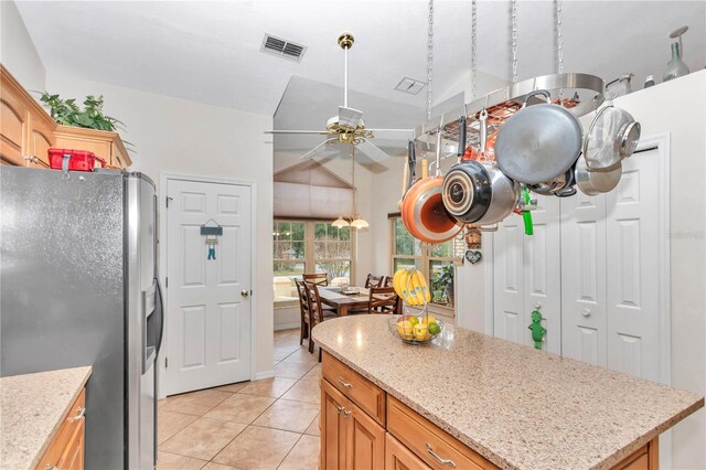 kitchen featuring visible vents, ceiling fan, a kitchen island, stainless steel refrigerator with ice dispenser, and light tile patterned flooring