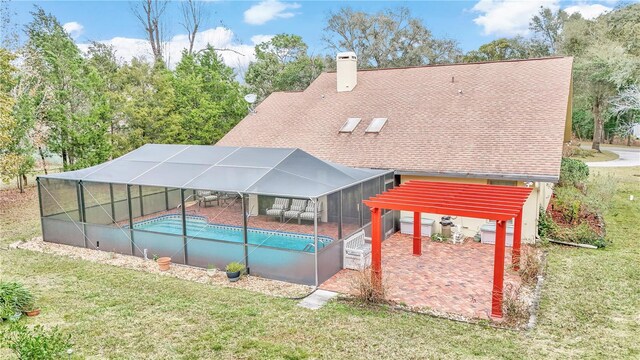 pool with a yard, a patio, and glass enclosure