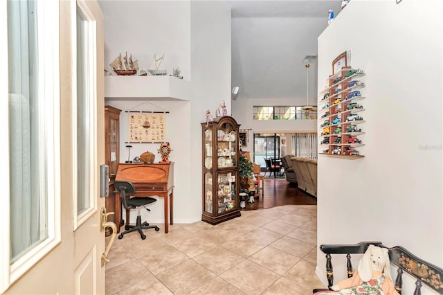 entryway featuring light tile patterned flooring and a towering ceiling