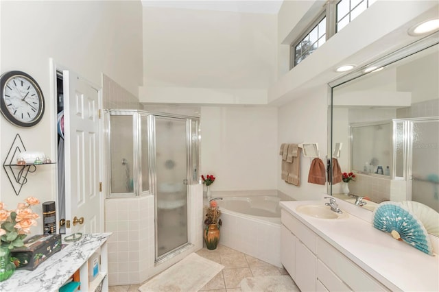 bathroom featuring a stall shower, tile patterned flooring, a garden tub, and vanity