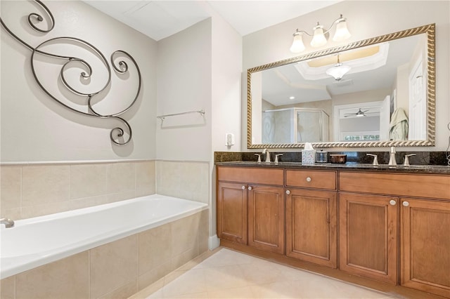 bathroom with shower with separate bathtub, tile patterned flooring, a tray ceiling, ceiling fan, and vanity