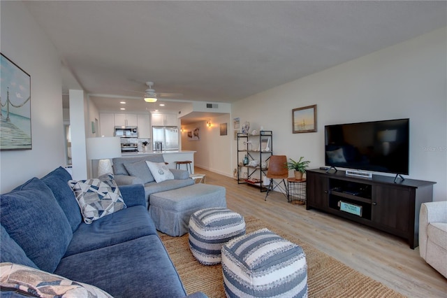 living room featuring light wood-type flooring and ceiling fan