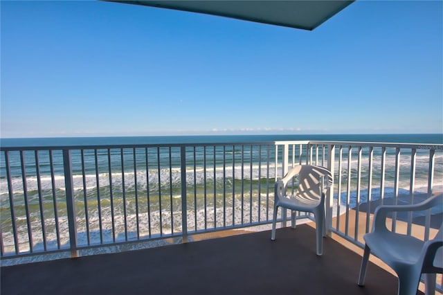 balcony featuring a water view and a view of the beach