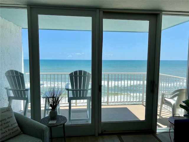 5203 S Atlantic Ave Unit 815B, New Smyrna Beach, FL 32169 - doorway to outside featuring a beach view, wood finished floors, and a water view