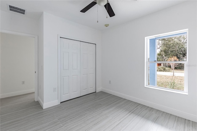 unfurnished bedroom with ceiling fan and a closet