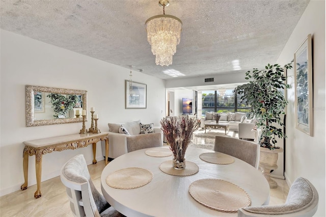 dining area with a textured ceiling and a chandelier