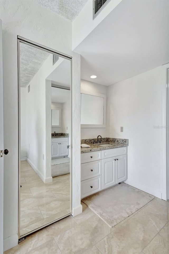 bathroom with vanity and a textured ceiling