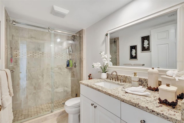 bathroom with walk in shower, vanity, and toilet