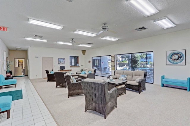 tiled living room featuring ceiling fan and a textured ceiling