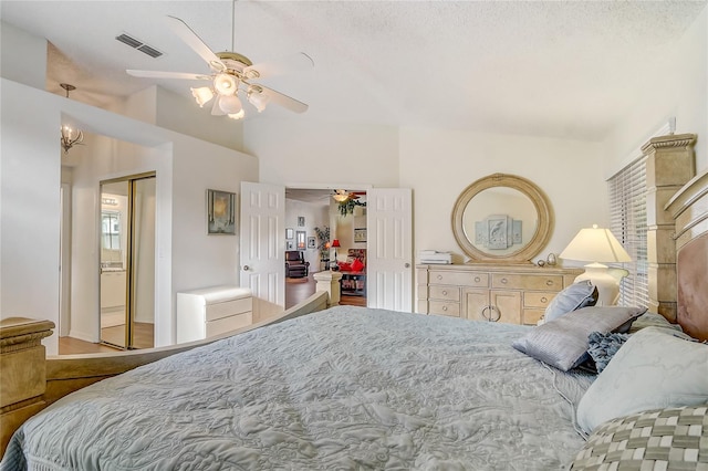 bedroom with a textured ceiling, a closet, ceiling fan, and lofted ceiling