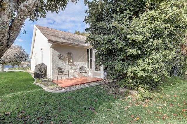 rear view of property featuring a yard and a patio