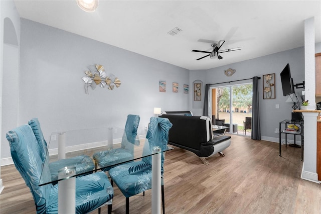 dining space with ceiling fan and wood-type flooring