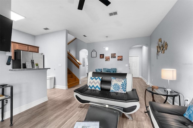 living room featuring ceiling fan and light wood-type flooring