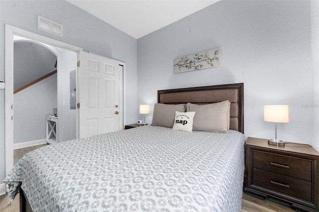 bedroom with electric panel and light hardwood / wood-style flooring