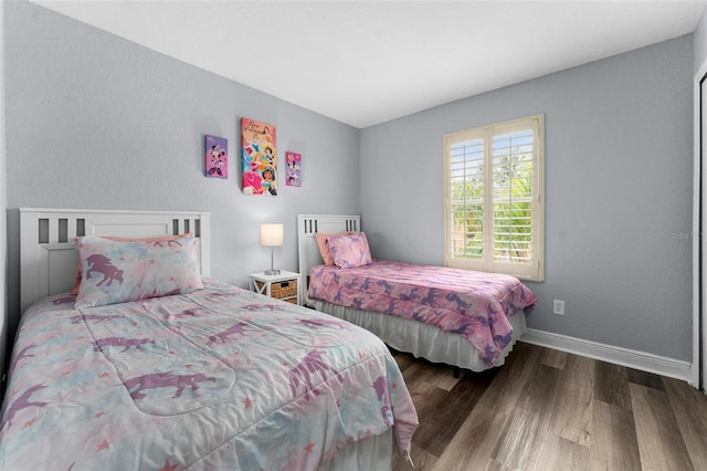 bedroom with dark hardwood / wood-style flooring