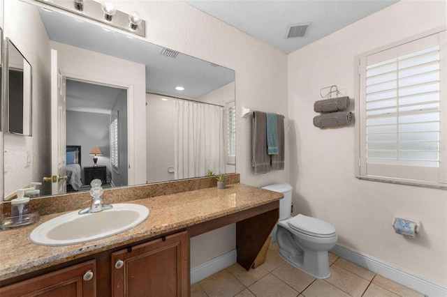 bathroom featuring walk in shower, tile patterned flooring, vanity, and toilet