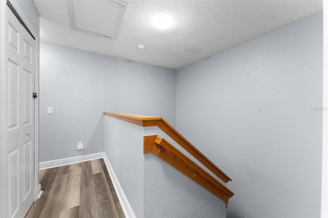 hallway featuring wood-type flooring and a textured ceiling