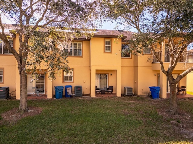 rear view of house featuring a lawn, a patio area, and central AC