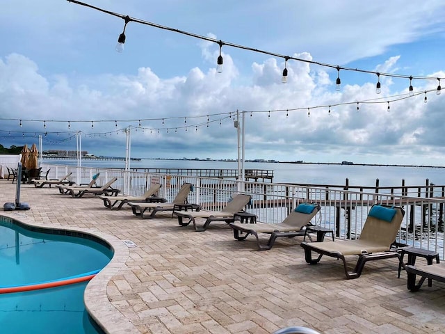 view of pool featuring a water view and a patio area