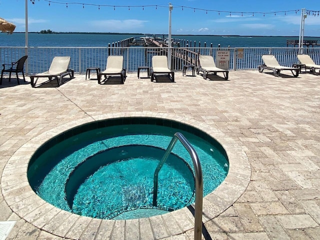 view of pool featuring a community hot tub and a water view