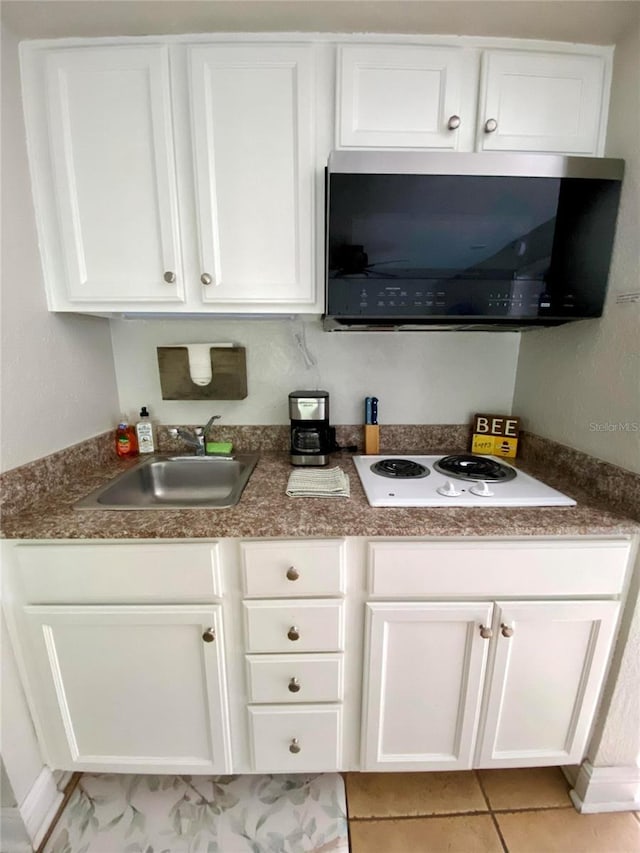 kitchen with white cabinetry, light tile patterned floors, sink, and white electric stovetop