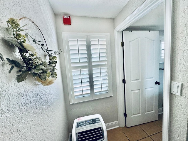 hall featuring heating unit and light tile patterned floors