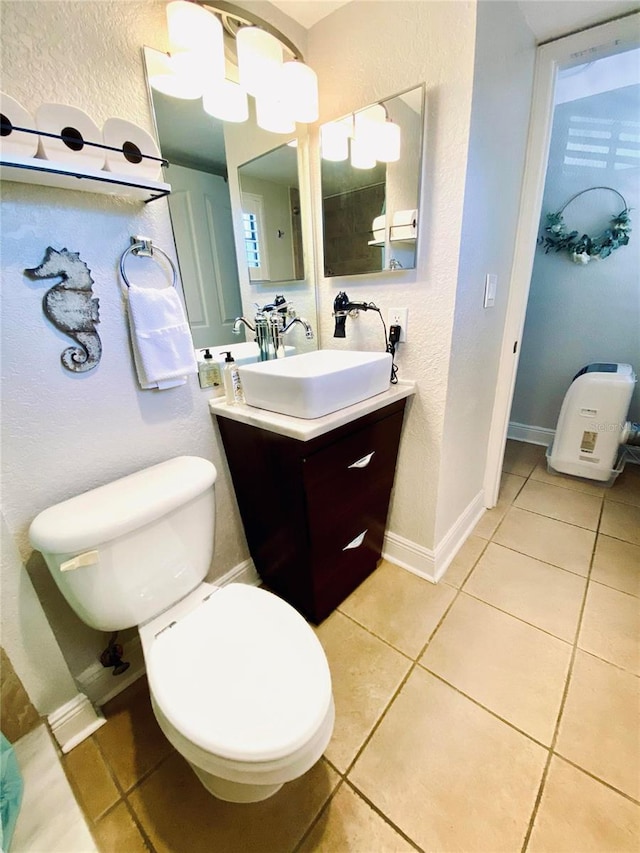 bathroom with tile patterned flooring, vanity, and toilet