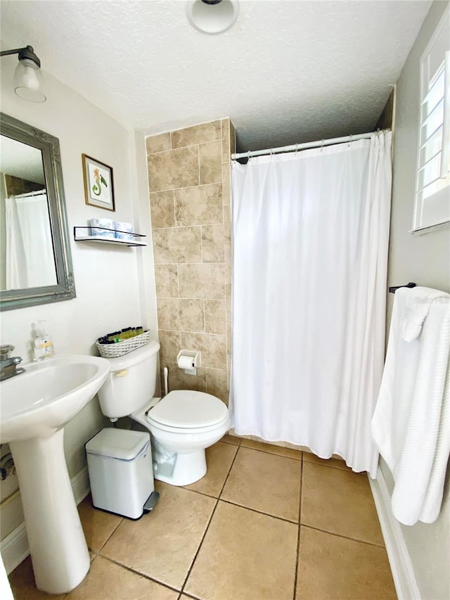 bathroom with tile walls, a textured ceiling, curtained shower, tile patterned floors, and toilet