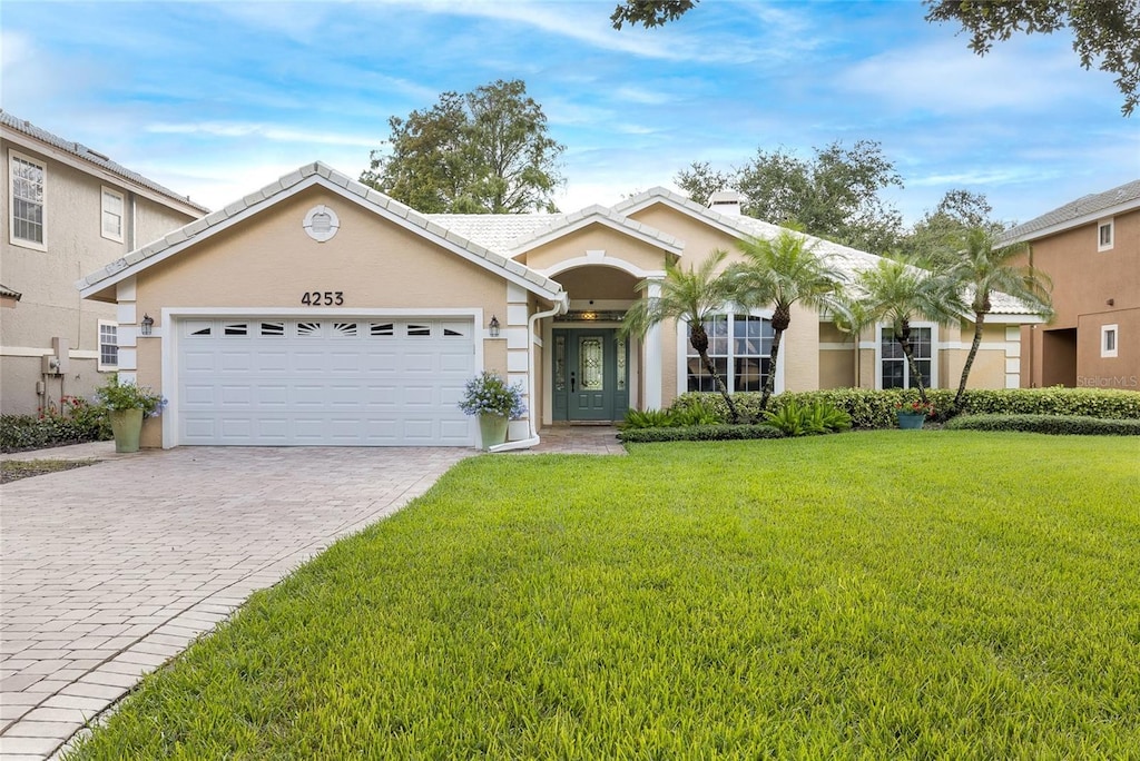 view of front of home with a garage and a front lawn