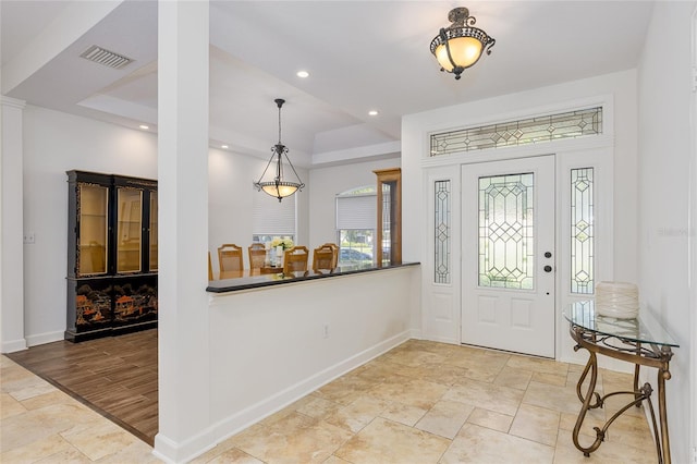 foyer featuring light wood-type flooring and a tray ceiling