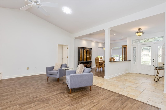 interior space featuring ceiling fan, vaulted ceiling, ornate columns, and light hardwood / wood-style flooring