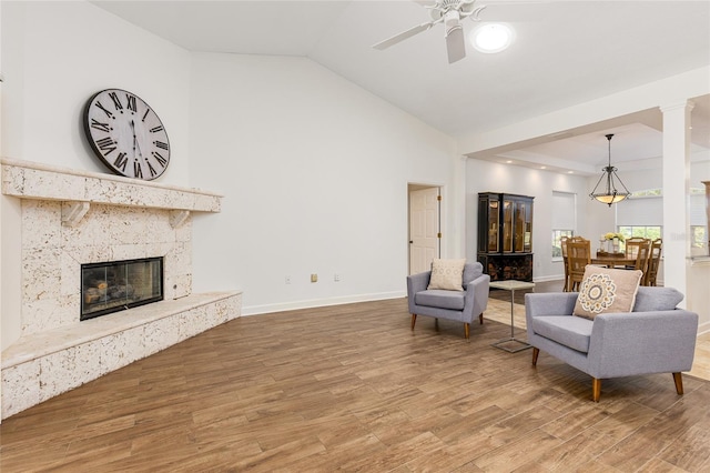 living room with hardwood / wood-style flooring, ceiling fan, lofted ceiling, and a premium fireplace