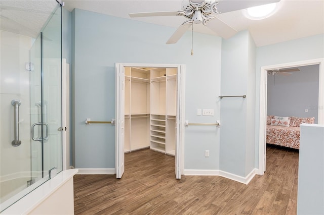 bathroom featuring walk in shower, hardwood / wood-style flooring, and ceiling fan