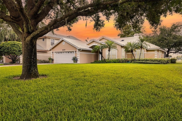 view of front of property featuring a garage and a yard