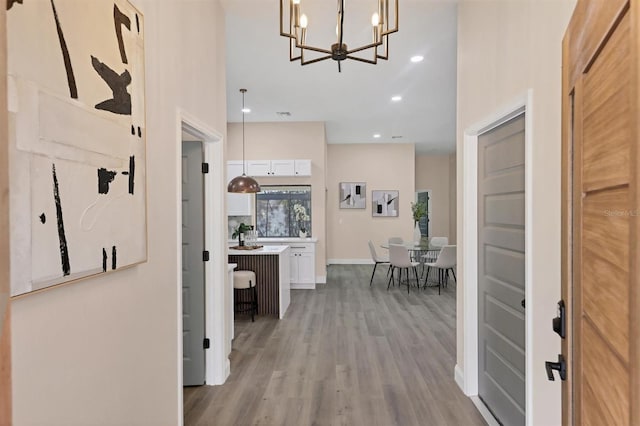 foyer entrance with a chandelier and light wood-type flooring