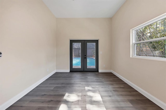 empty room featuring french doors and dark wood-type flooring