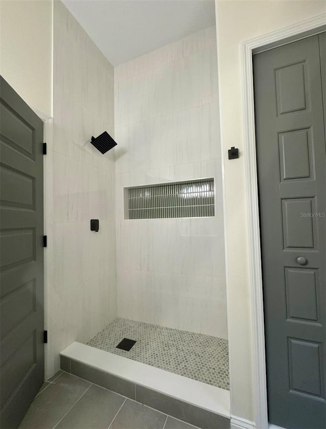 bathroom with tile patterned floors and tiled shower