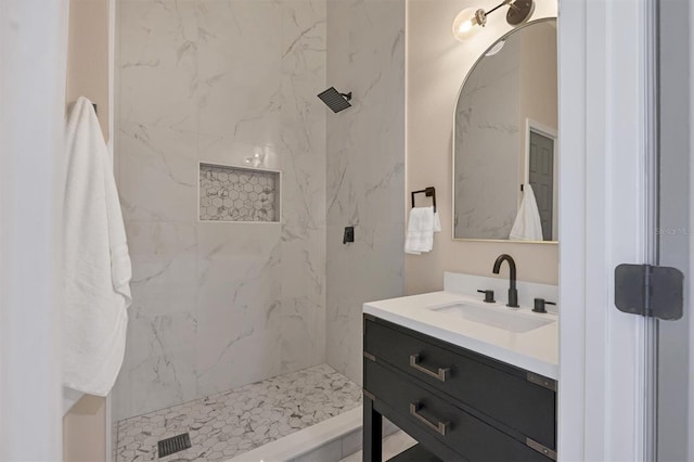 bathroom featuring a tile shower and vanity