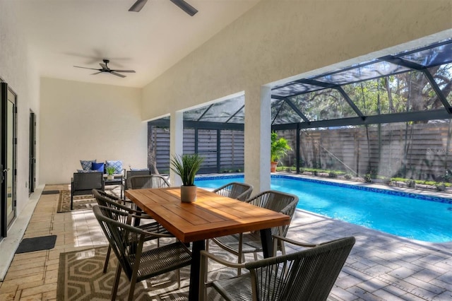 view of swimming pool featuring glass enclosure, ceiling fan, and a patio