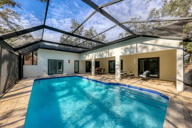 view of swimming pool with glass enclosure, a patio, and french doors