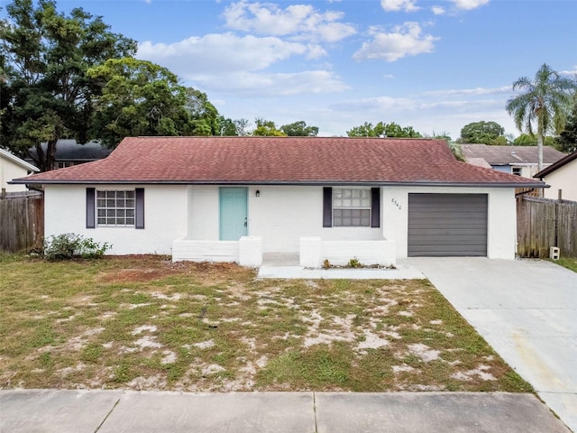 ranch-style house with a garage and a front lawn