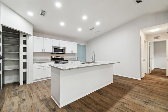 kitchen featuring white cabinets, appliances with stainless steel finishes, sink, and an island with sink