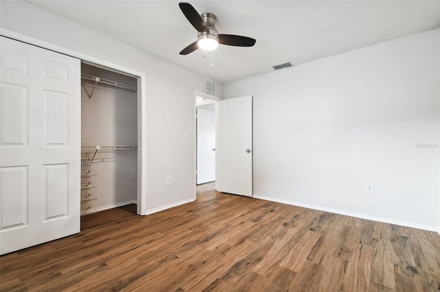 unfurnished bedroom with ceiling fan, dark hardwood / wood-style flooring, and a closet