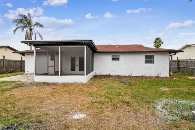 back of property with a yard and a sunroom