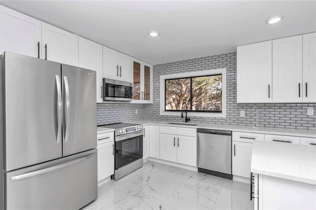 kitchen with sink, decorative backsplash, stainless steel appliances, and white cabinets