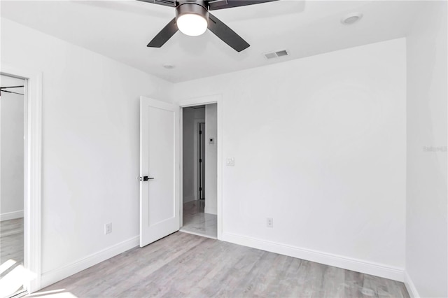 spare room with ceiling fan and light wood-type flooring